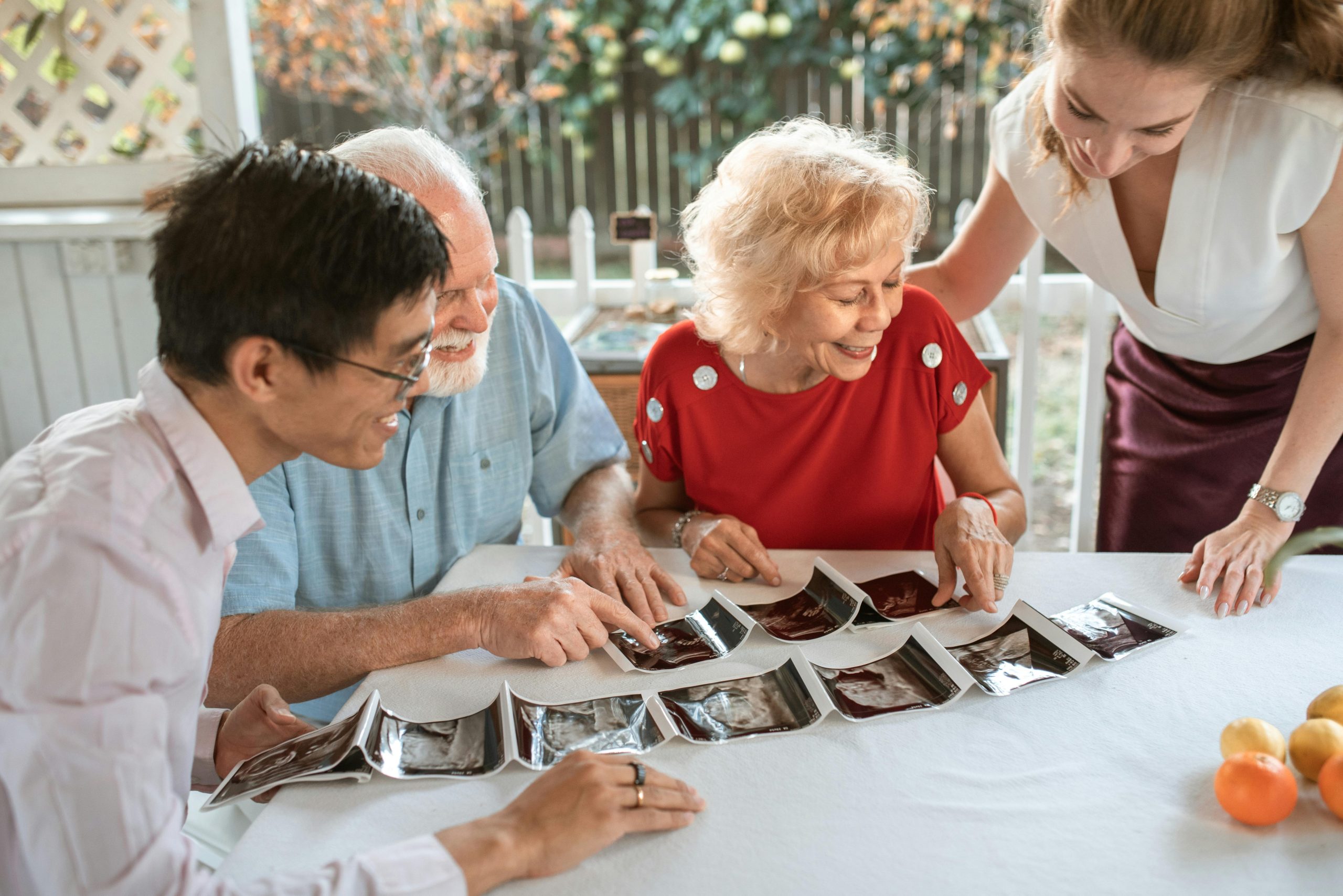 A happy family celebrating a pregnancy announcement with ultrasound photos.